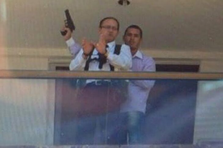 Mensageiro do hotel algemado na varanda de um dos quartos com o sequestrador armado atrás (Foto: Polícia Civil/Divulgação)