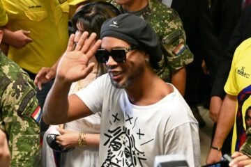 O ex-jogador Ronaldinho Gaúcho acena ao chegar ao Aeroporto Internacional Silvio Pettirossi, em Luque, perto de Assunção — Foto: Norberto Duarte / AFP Photo