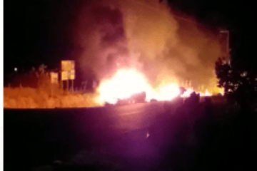 Carro pega fogo após bater em poste.