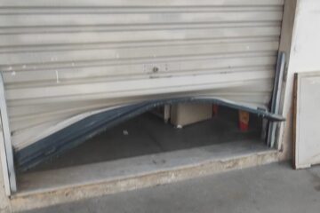 Porta danificada do comércio. Foto: Polícia Militar